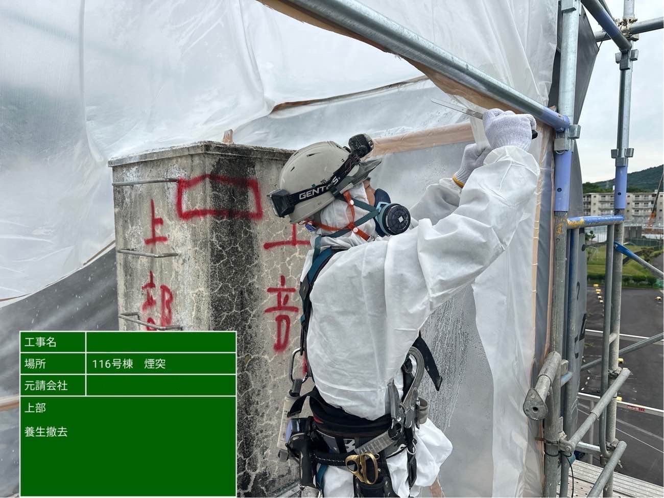 保護手袋を着用した作業責任者が、煙突内の除去完了箇所を確認している様子