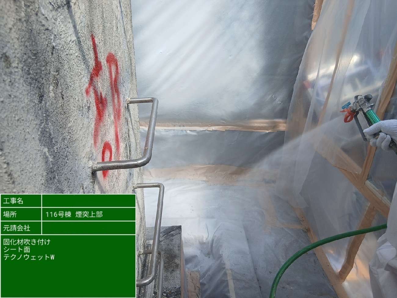 作業員が煙突周辺の養生シート面に固化材を吹き付けている様子