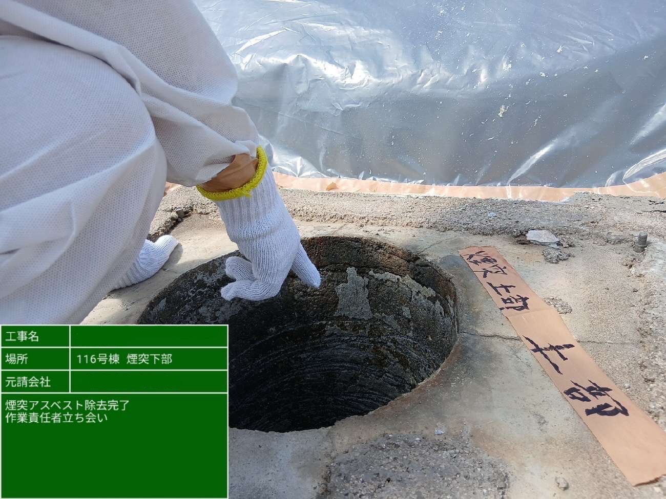 保護手袋を着用した作業責任者が、煙突内の除去完了箇所を確認している様子