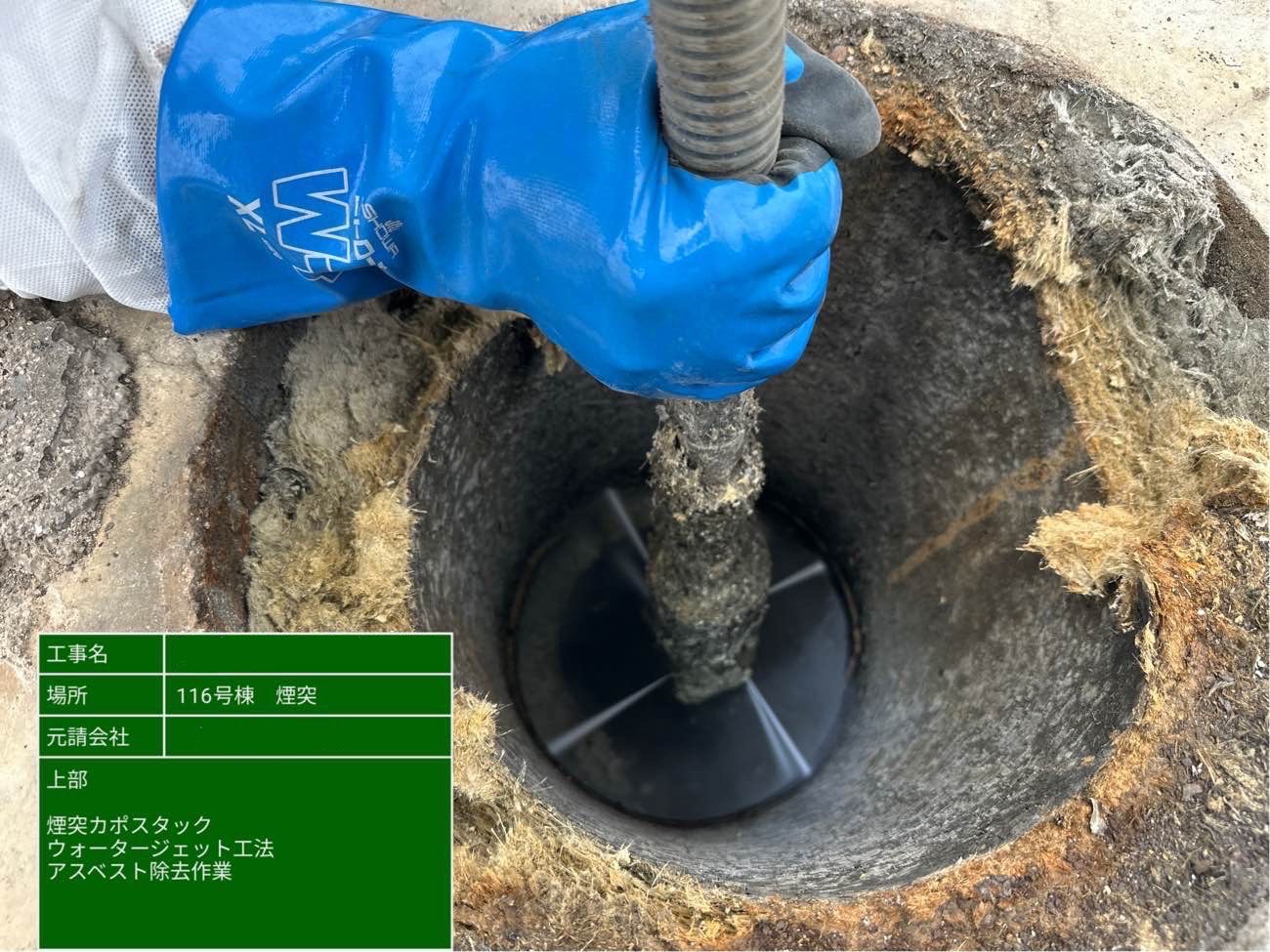 煙突開口部から内部へノズルを差し込み、ウォータージェットで除去作業を行う様子