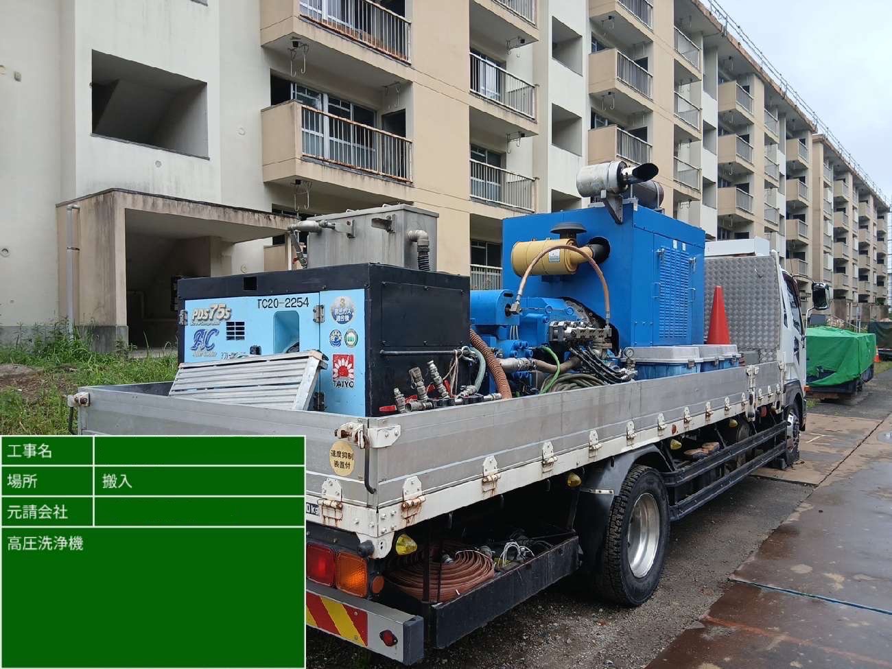アパート前に停車したトラックに積載された大型高圧洗浄機の様子