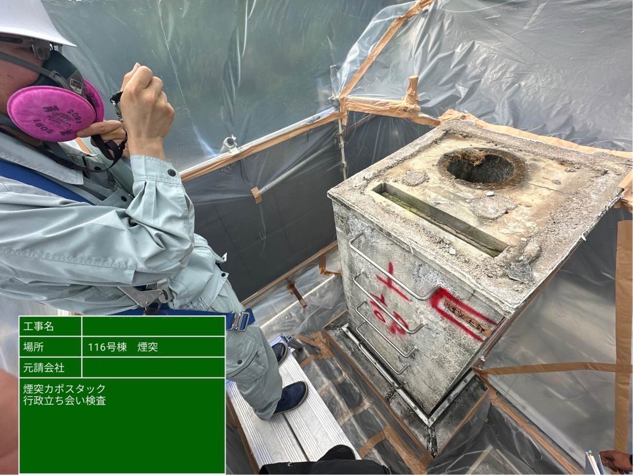 煙突上部で行政担当者が検査をしている様子