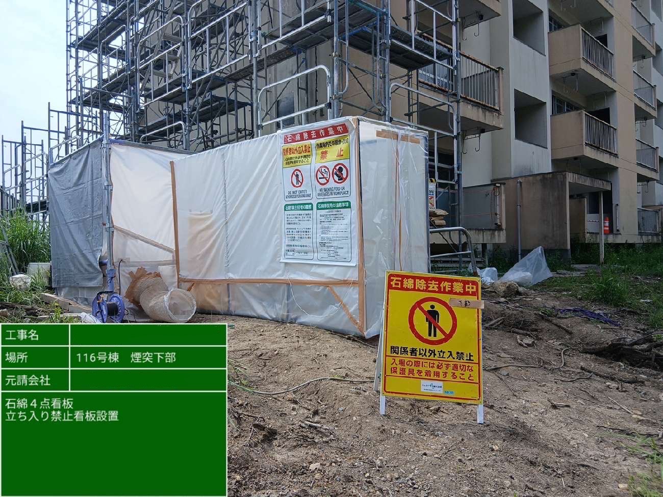 煙突下部に石綿除去作業中と立入禁止の2種類の看板を設置した様子