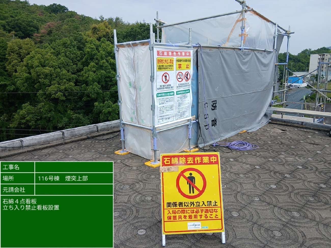 煙突上部に石綿除去作業中と立入禁止の看板を設置した様子