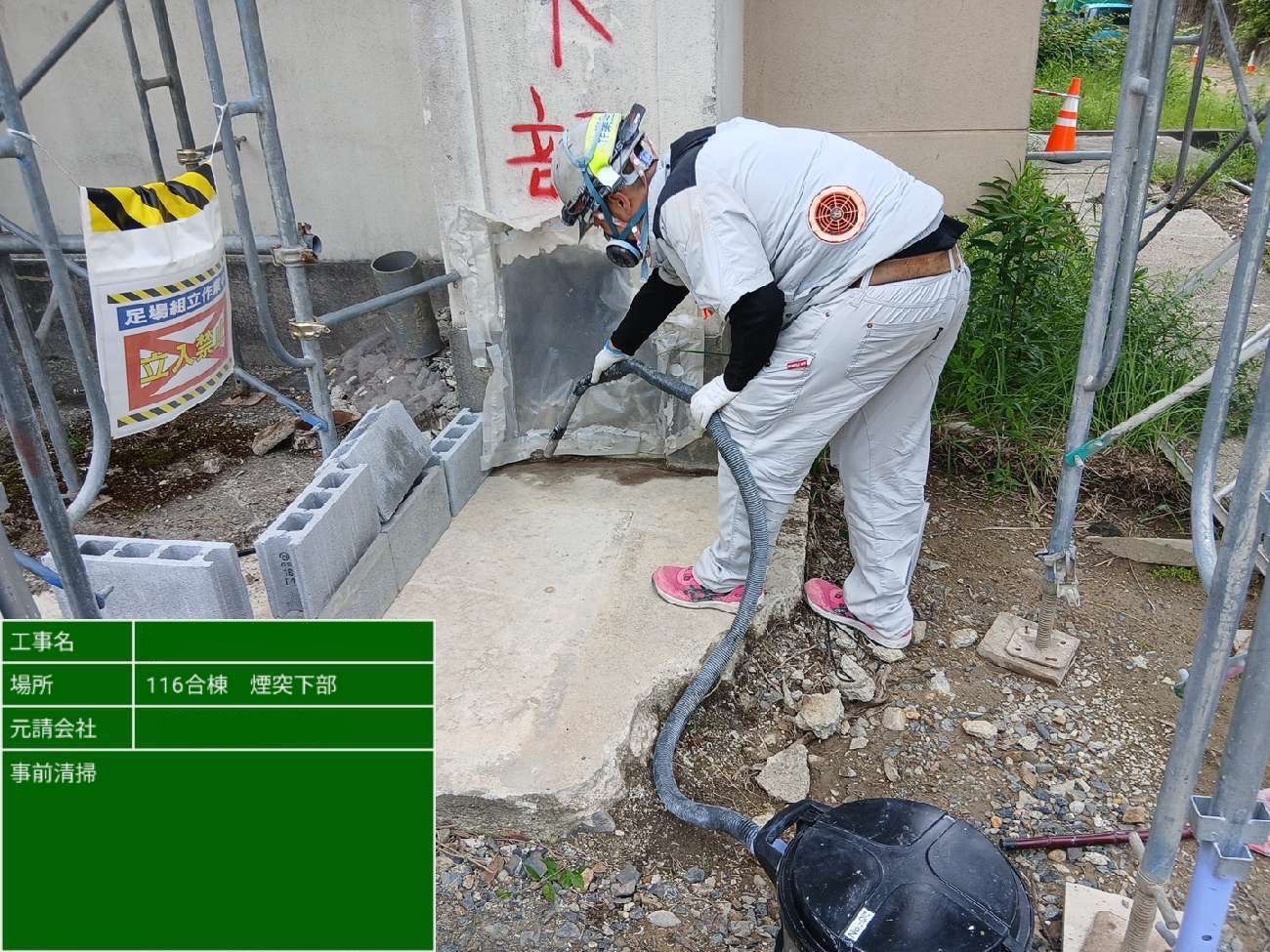 煙突下部の開口部を事前清掃している作業員の様子