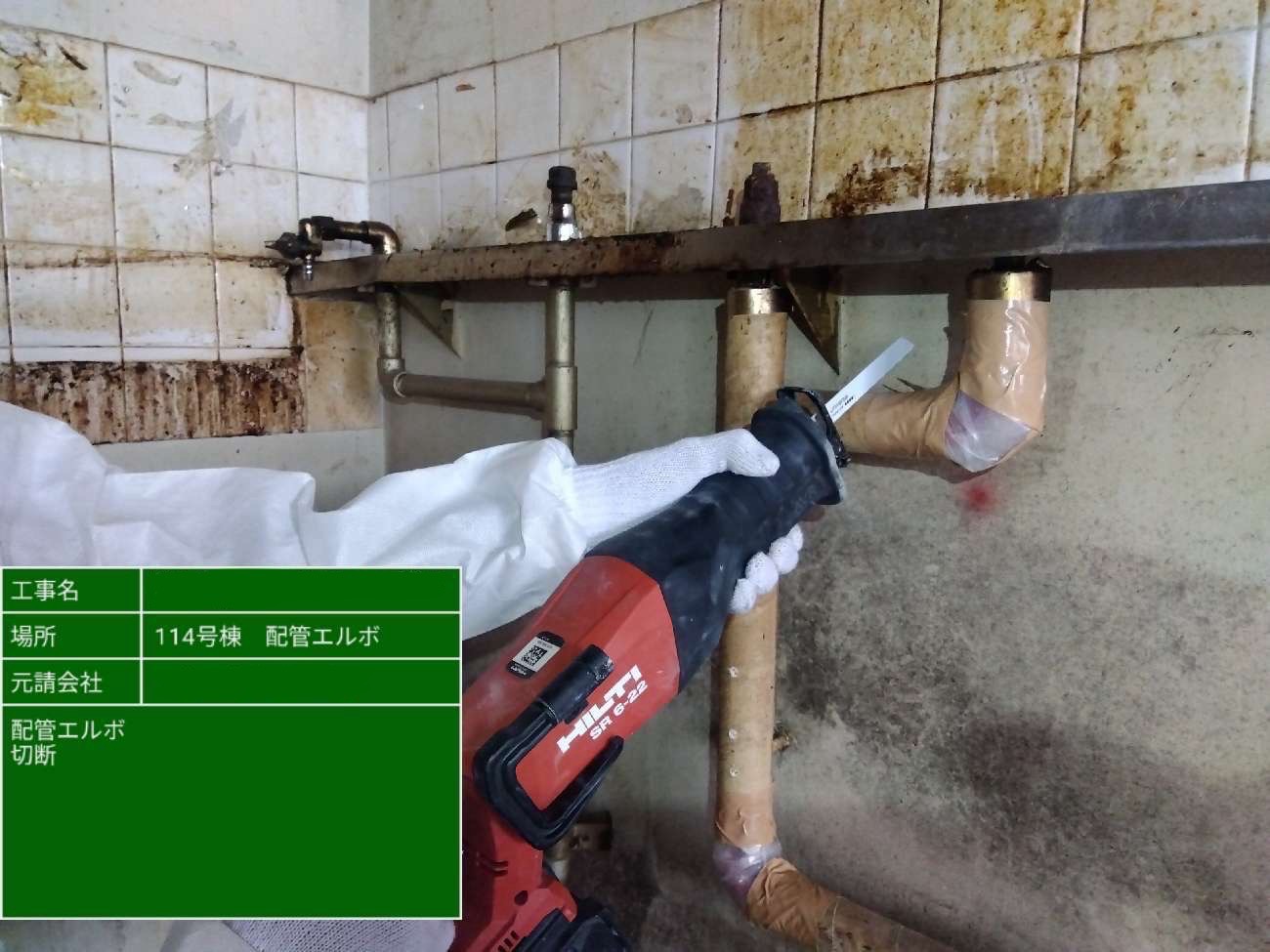 電動工具を使用して、養生済みの配管エルボを切断している様子