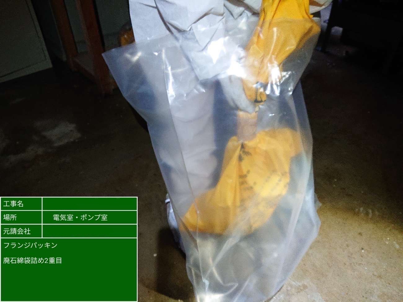 一次袋入りのアスベスト廃棄物を透明な二次袋に収容している様子