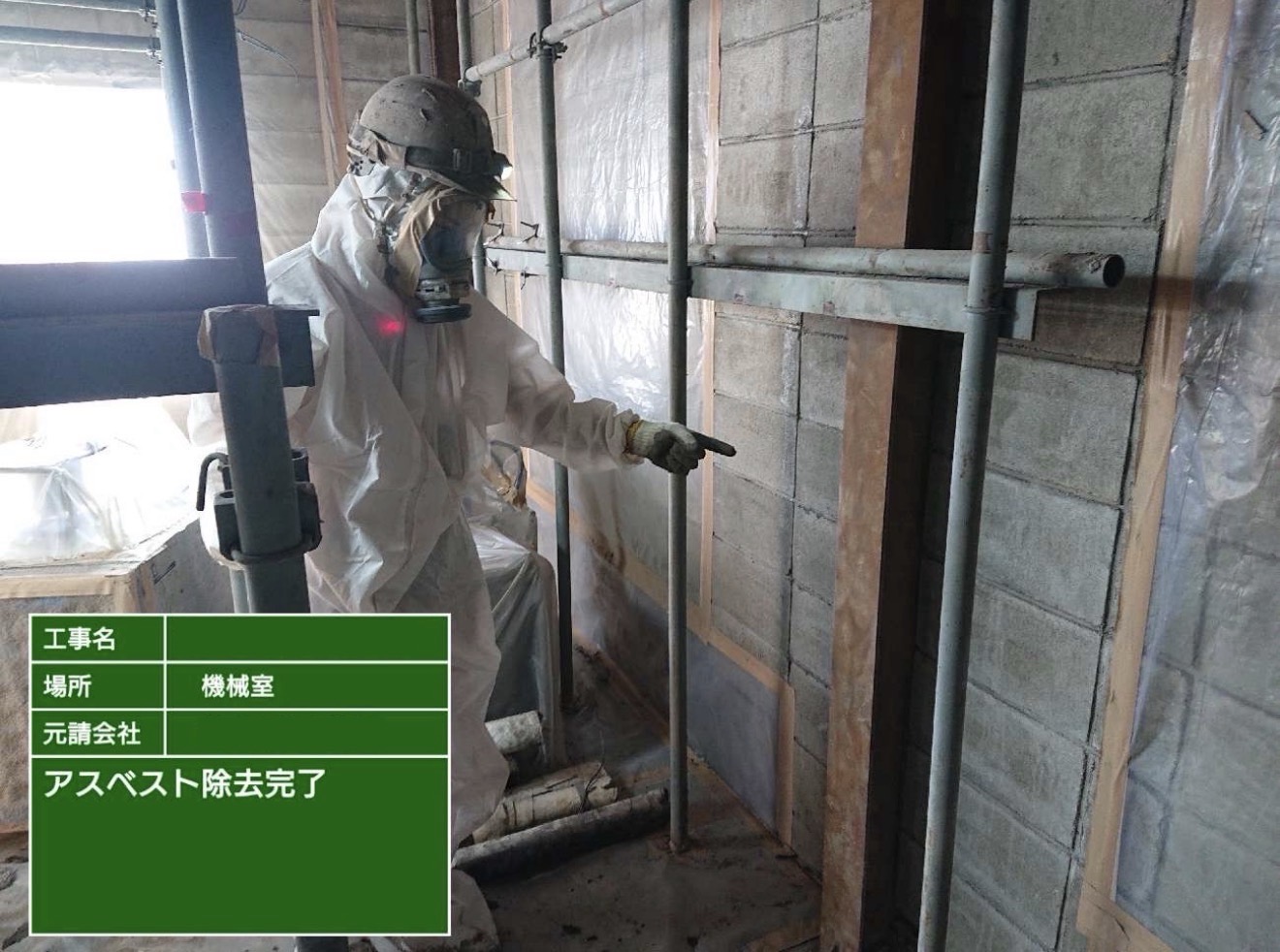機械室でアスベスト除去完了を確認する作業員