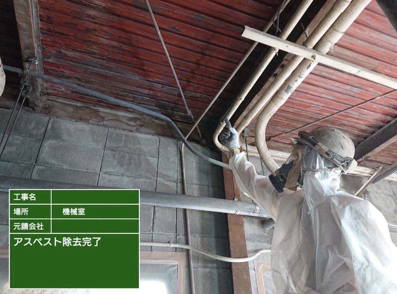 天井部分のアスベスト除去完了を指差し確認する作業員