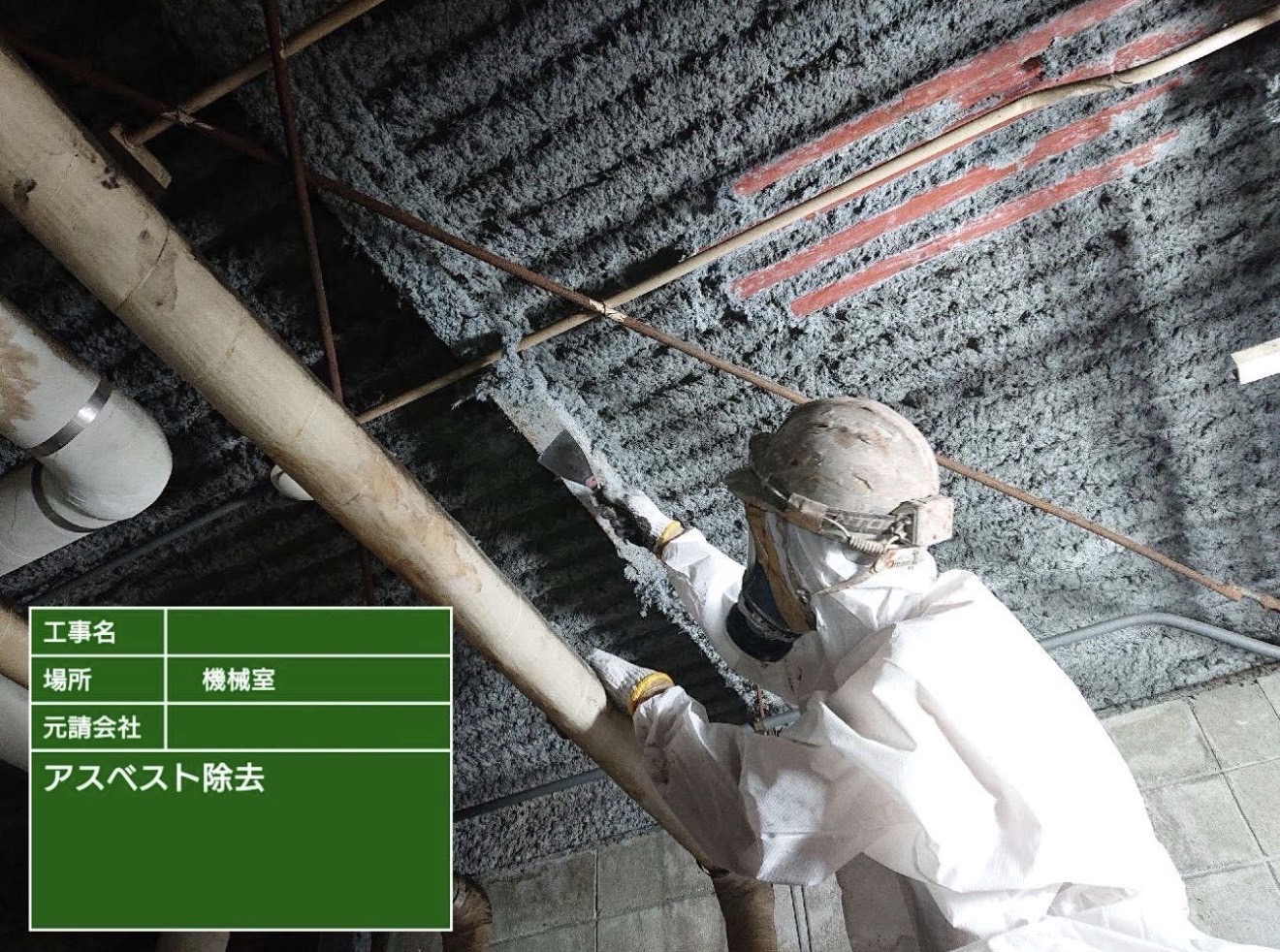 吹付アスベストを手作業で除去している作業員